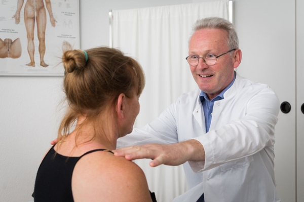 Ein Arzt untersucht eine Rehabilitandin Ein Arzt untersucht eine Rehabilitandin