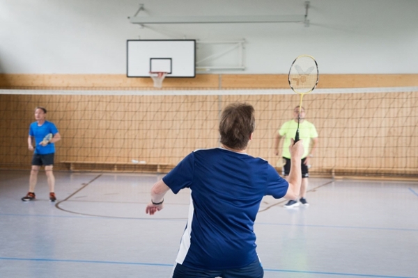 Drei Personen bei Badminton spielen